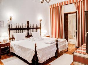 a bedroom with a large bed with white sheets at Hotel Residencial Alentejana in Coimbra