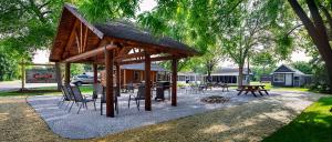 a pavilion with chairs and tables and a fire pit at Big River Escape Riverside Cabins in Buffalo City