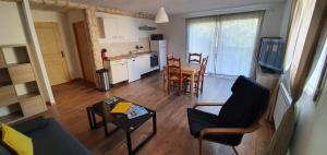 een keuken en een woonkamer met een tafel en stoelen bij Logement, rez-de-jardin d’une maison, orée du bois in Vals-les-Bains