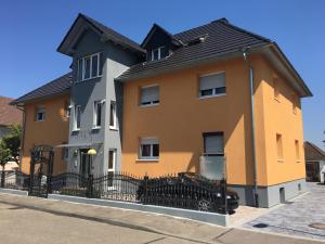 a yellow and orange house with a black roof at Apartment Euro AS in Kappel-Grafenhausen