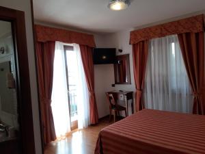 a hotel room with a bed and a window at Hotel B&B Fortuna in Costermano