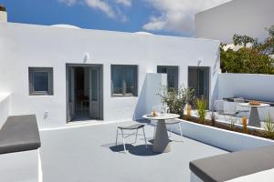 a patio with tables and chairs on a white building at Divine View Sol Homes in Fira
