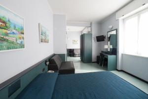 a bedroom with a bed and a couch and a window at Hotel Tirreno in Genoa