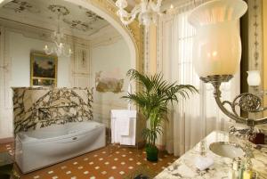 a bathroom with a large tub and a large mirror at Villa Olmi Firenze in Florence