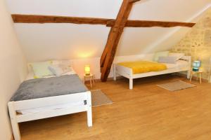 a bedroom with two beds in a attic at La Pause du Perche - gîte au pied de la forêt in La Perrière