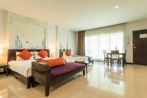 a hotel room with a bed and a couch at Krabi Aquamarine Resort - SHA Plus in Ao Nang Beach