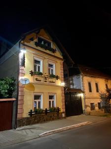 a building with windows and plants on it at night at Casa cu Cerdac in Sighişoara