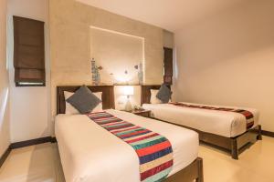 a hotel room with two beds in a room at Krabi Aquamarine Resort - SHA Plus in Ao Nang Beach