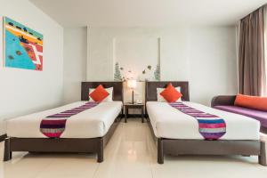 a bedroom with two beds and a couch at Krabi Aquamarine Resort - SHA Plus in Ao Nang Beach