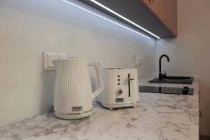 two white appliances sitting on a counter in a kitchen at Apartament Mariva B106 z balkonem - Pobierowo - przy samym morzu - obiekt Euronia in Pobierowo