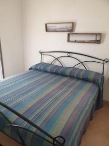a bed with a striped comforter in a bedroom at Lito’s house in Villasimius in Villasimius
