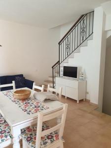 a dining room with a table and a tv at Lito’s house in Villasimius in Villasimius