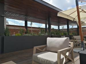 a patio with a chair and an umbrella at Hotel Boutique Rayón 50 in Morelia