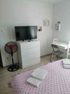 a living room with a tv and a dresser with a desk at AmigoHD² in Hunedoara