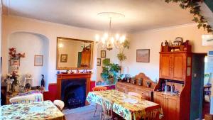 een woonkamer met 2 tafels en een open haard bij The Laurels At Inchbrook in Stroud