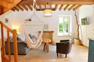 een woonkamer met een hangmat aan het plafond bij La Pause du Perche - gîte au pied de la forêt in La Perrière