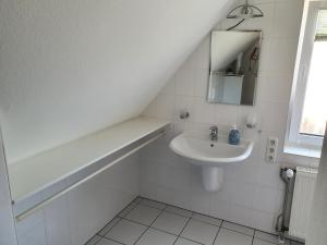 a white bathroom with a sink and a mirror at Ferienhaus Gräbner in Lügde