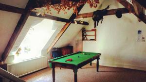 a room with a pool table in a attic at The Laurels At Inchbrook in Stroud
