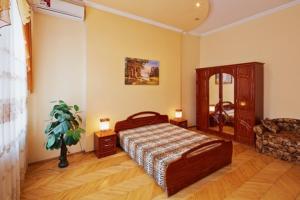 um quarto com uma cama e uma cadeira num quarto em Кулиша 25-Трёхкомнатная возле Оперы em Lviv