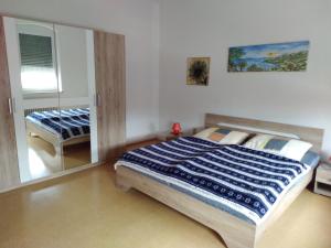 ein Schlafzimmer mit einem großen Bett und einem Spiegel in der Unterkunft Ferienwohnung Colin im schönen Weserbergland Nähe Freizeitpark in Salzhemmendorf