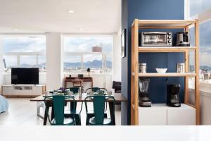 ein Wohnzimmer mit einem Tisch und grünen Stühlen in der Unterkunft LOFT DE LUJO / MIRADOR ALAMEDA CENTRAL in Mexiko-Stadt