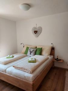a bedroom with two beds and a heart on the wall at Familienbauernhof Bairau Grubhörndl in Scheffsnoth