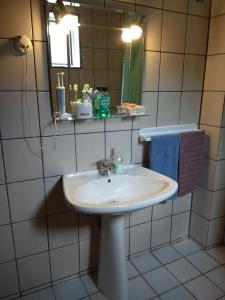 een badkamer met een witte wastafel en een spiegel bij Villa Alexandra in Iraklitsa