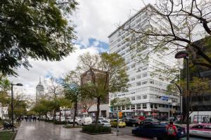 eine Stadtstraße mit Autos vor einem hohen Gebäude in der Unterkunft LOFT DE LUJO / MIRADOR ALAMEDA CENTRAL in Mexiko-Stadt