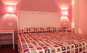a bedroom with a large bed with two lamps at Hotel O'scià in Lampedusa