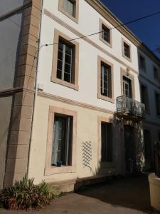 Un edificio blanco con ventanas y balcón. en Les Colonnades, en Moussan