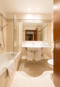 ein Badezimmer mit einem Waschbecken, einer Badewanne und einem WC in der Unterkunft Hotel Eden in Levico Terme