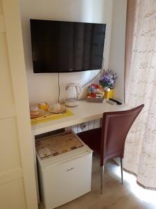 una scrivania con TV e una sedia in camera di Borgo Vaticano 84 Guest House a Roma Altre 17 foto