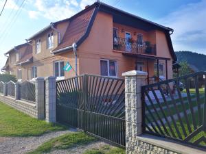 a house with a gate and a fence at Gabriella vendégház in Lăzarea
