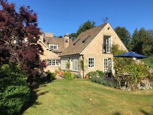 a house with an umbrella in the yard at The Old School, Idbury, OX7 6RU in Chipping Norton