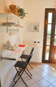 una cocina con 2 sillas negras y una barra en B&B Sarita's Rooms, en Certosa di Pavia