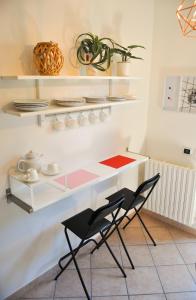 cocina con encimera blanca y 2 sillas en B&B Sarita's Rooms, en Certosa di Pavia