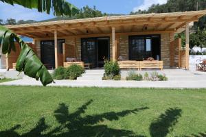a wooden cabin with a porch and a lawn at Icons Experience in Parga