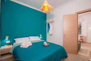 a blue bedroom with a bed with towels on it at Rilassunte Luxury apartments in Potos