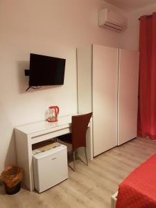 una camera da letto con una scrivania e una TV a parete di Borgo Vaticano 84 Guest House a Roma