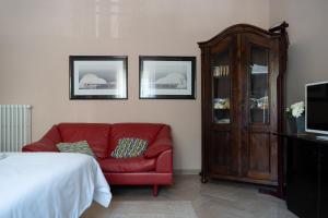 a living room with a red couch and a cabinet at Gino's House in Gubbio