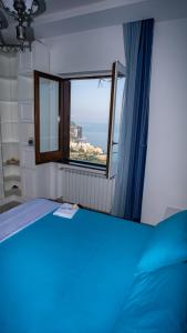 ein Schlafzimmer mit einem blauen Bett und einem Fenster in der Unterkunft Mira Vico Apartments in Vico Equense