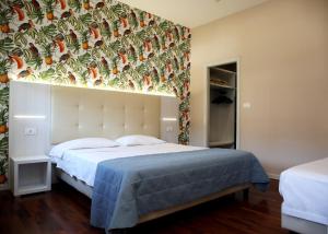 a bedroom with a bed with a large headboard at Grand Hotel Panoramic in Montecatini Terme