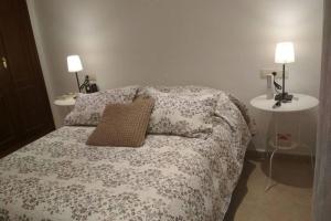 a bedroom with a bed with a pillow and a table at Beautiful House Sierrecilla in Humilladero