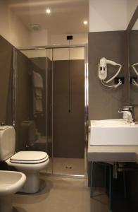 a bathroom with a shower and a toilet and a sink at Grand Hotel Panoramic in Montecatini Terme