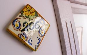 a vase hanging on a wall next to a ladder at Hotel O'scià in Lampedusa