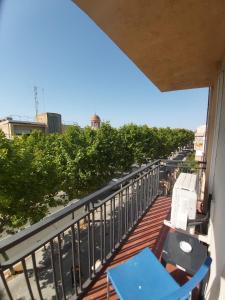 un balcón con una mesa azul y sillas. en Gatell Hotel, en Vilanova i la Geltrú