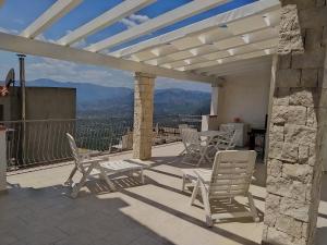 eine Terrasse mit einem Tisch und Stühlen auf dem Balkon in der Unterkunft Appartamento La terrazza in Baunei