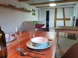 a wooden table with a bowl and plates and glasses at Apartment Happy Memories in Titisee-Neustadt