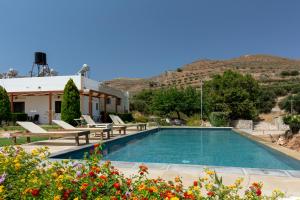 a pool in front of a house with mountains in the background at Agarathos Traditional Rooms with Pool in Kissamos