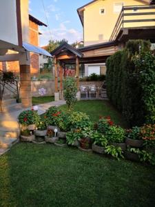 a garden with flowers and plants in a yard at Apartman Volijak in Jajce